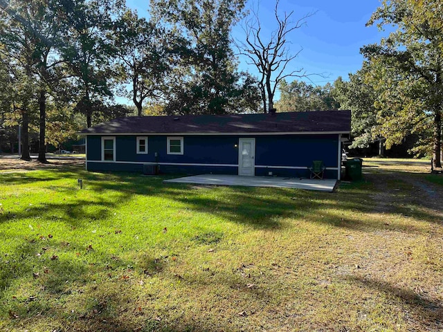 back of house with a yard and a patio