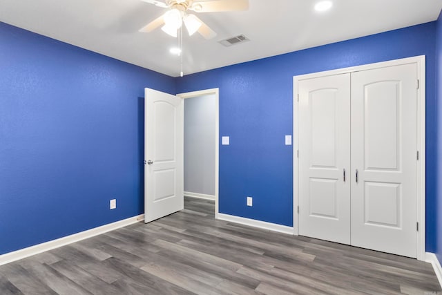 unfurnished bedroom featuring ceiling fan, a closet, and dark hardwood / wood-style flooring