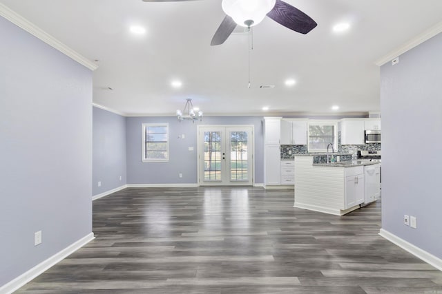 unfurnished living room with sink, french doors, dark wood-type flooring, ceiling fan with notable chandelier, and crown molding