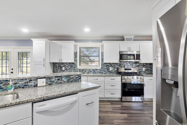 kitchen featuring dark hardwood / wood-style floors, tasteful backsplash, ornamental molding, white cabinetry, and appliances with stainless steel finishes