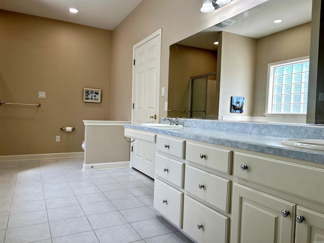 bathroom featuring walk in shower, vanity, tile patterned flooring, and toilet