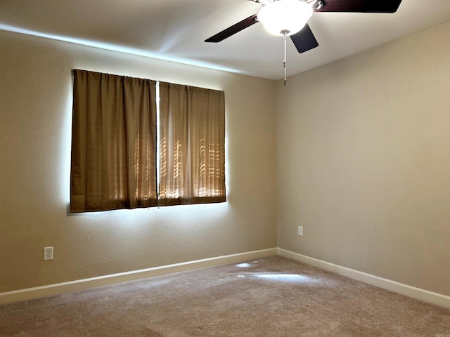 carpeted spare room featuring ceiling fan