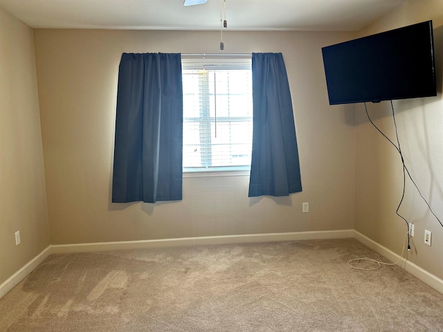 carpeted spare room featuring ceiling fan