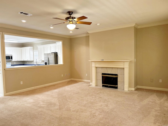 unfurnished living room with crown molding, light colored carpet, and ceiling fan