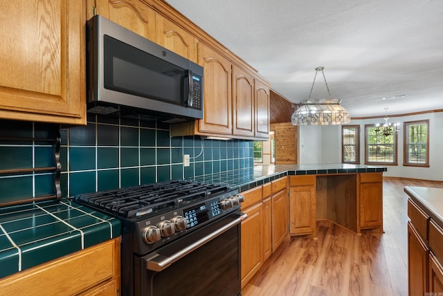 kitchen featuring light wood-type flooring, appliances with stainless steel finishes, plenty of natural light, and decorative backsplash