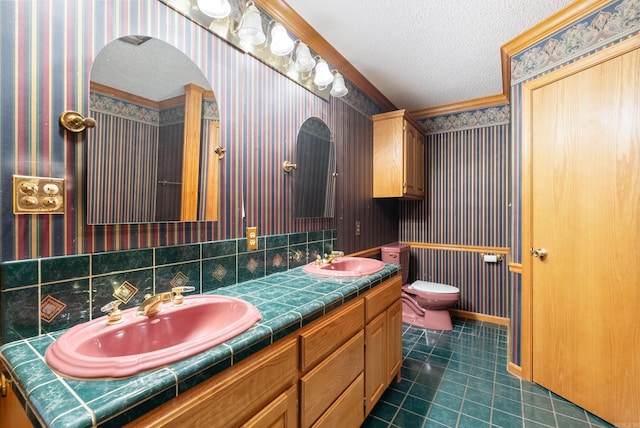 bathroom with vanity, tasteful backsplash, ornamental molding, toilet, and a textured ceiling