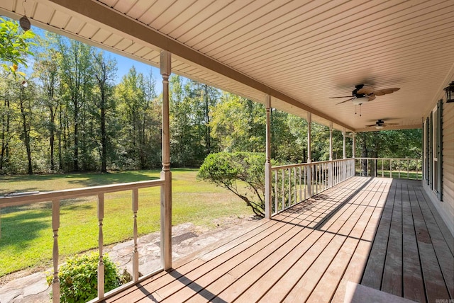 wooden deck featuring a lawn and ceiling fan