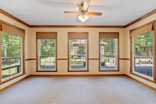 unfurnished sunroom featuring ceiling fan and a wealth of natural light