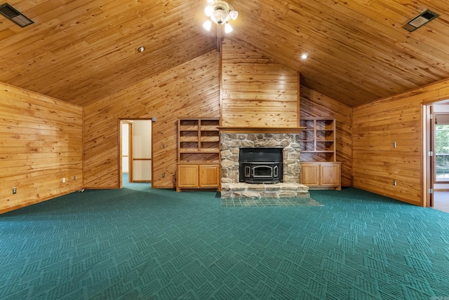 unfurnished living room featuring carpet floors, wood ceiling, wood walls, and a wood stove