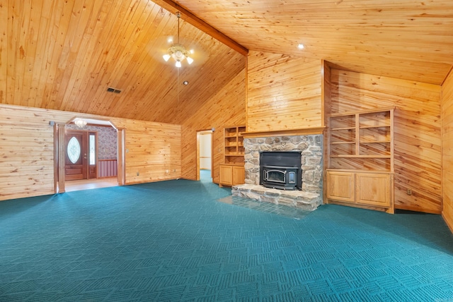 unfurnished living room with carpet flooring, beam ceiling, wood ceiling, wooden walls, and a wood stove