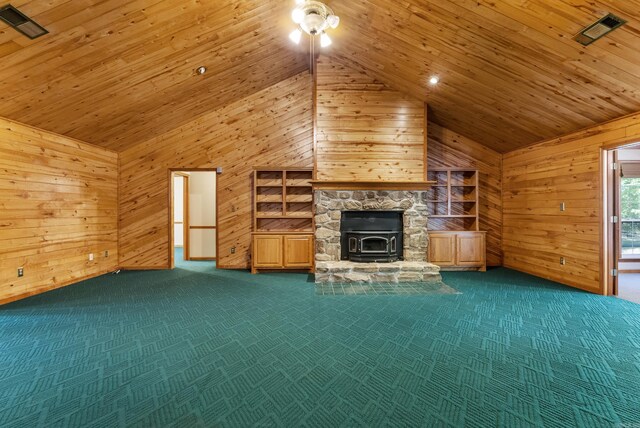 unfurnished living room with wood walls, wooden ceiling, carpet, and a wood stove