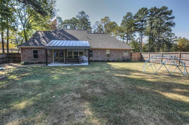 rear view of house featuring a yard and a patio area