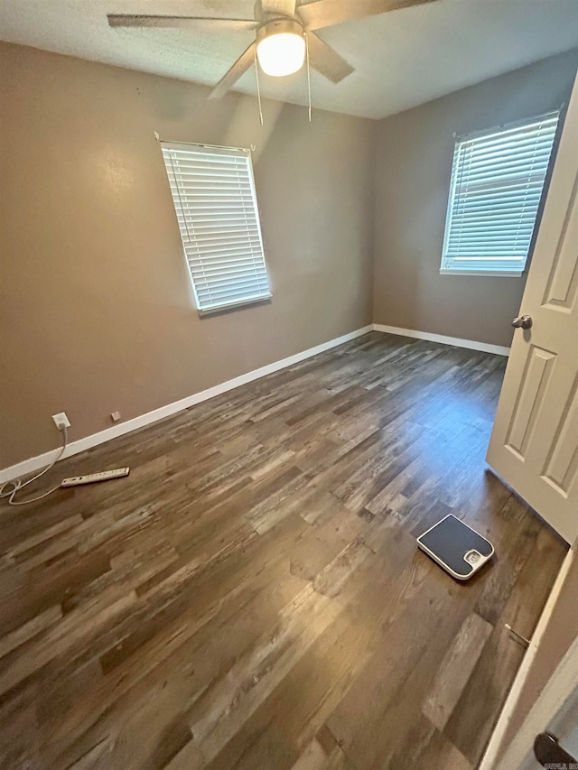 spare room featuring ceiling fan and dark wood-type flooring