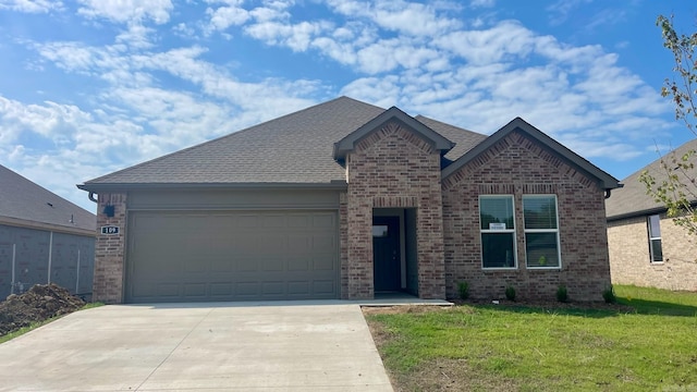 view of front of house with a garage and a front yard