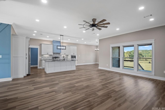 kitchen with white cabinets, an island with sink, pendant lighting, ornamental molding, and dark wood-type flooring