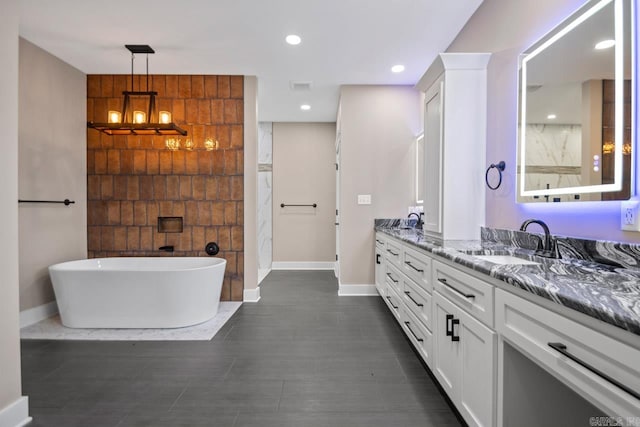 bathroom featuring an inviting chandelier, vanity, and a bathtub