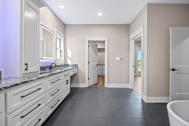 bathroom featuring vanity, hardwood / wood-style flooring, and a tub