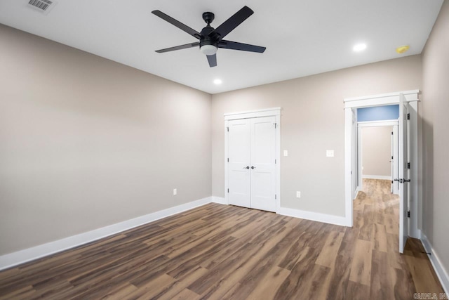 unfurnished bedroom with ceiling fan, a closet, and dark hardwood / wood-style floors