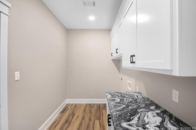 laundry room featuring wood-type flooring, washer hookup, cabinets, and hookup for an electric dryer