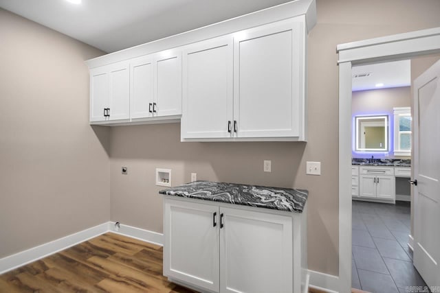 washroom with hookup for an electric dryer, hookup for a washing machine, cabinets, and dark hardwood / wood-style flooring