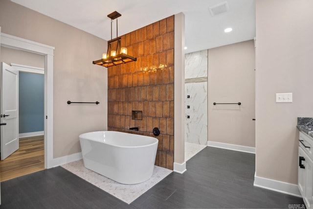 bathroom with plus walk in shower, hardwood / wood-style floors, and vanity