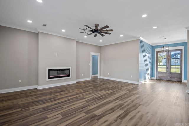 unfurnished living room with french doors, ceiling fan with notable chandelier, crown molding, and hardwood / wood-style floors