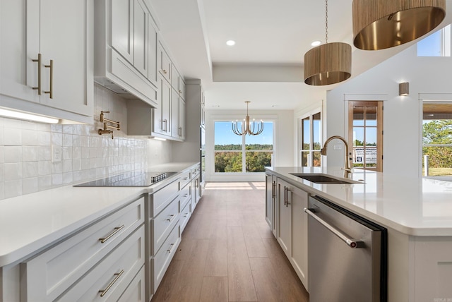 kitchen with dishwasher, white cabinets, and a kitchen island with sink