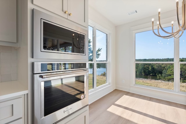 kitchen with stainless steel appliances, plenty of natural light, and light hardwood / wood-style floors