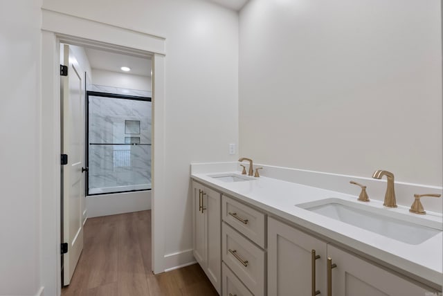 bathroom with hardwood / wood-style flooring, vanity, and a shower with shower door