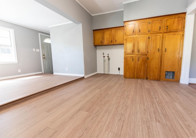 unfurnished living room with light hardwood / wood-style flooring and crown molding