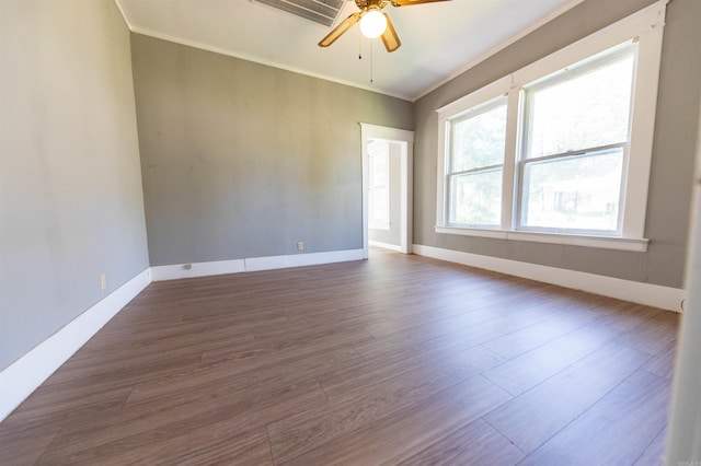 spare room featuring dark wood-type flooring, ornamental molding, and ceiling fan