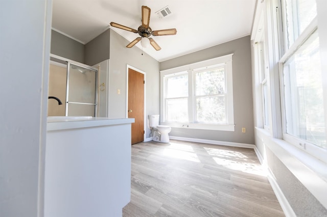 bathroom with ceiling fan, a shower with door, toilet, and wood-type flooring