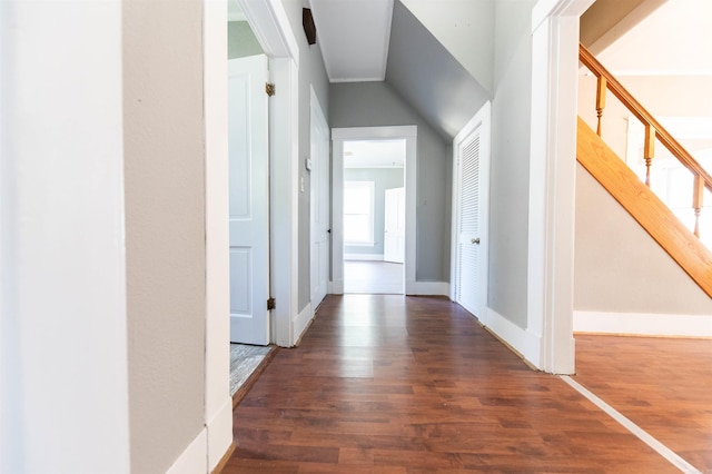 corridor with dark wood-type flooring and lofted ceiling