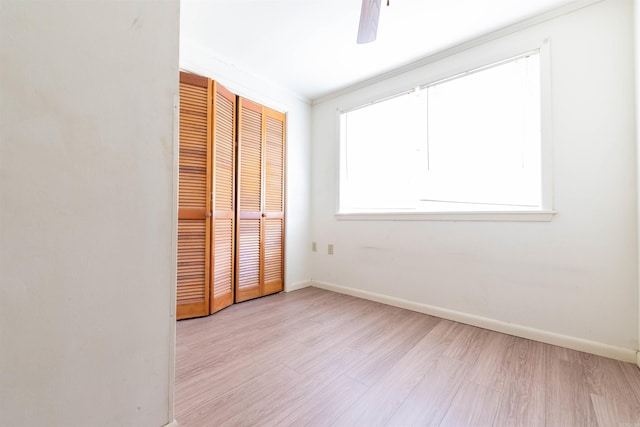 unfurnished bedroom with ceiling fan, a closet, crown molding, and light hardwood / wood-style floors