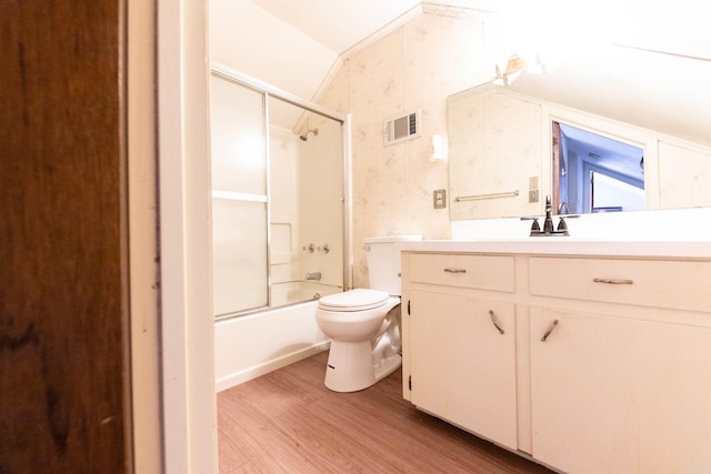 full bathroom featuring combined bath / shower with glass door, toilet, hardwood / wood-style floors, lofted ceiling, and vanity