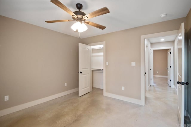 unfurnished bedroom with a closet, a walk in closet, and ceiling fan