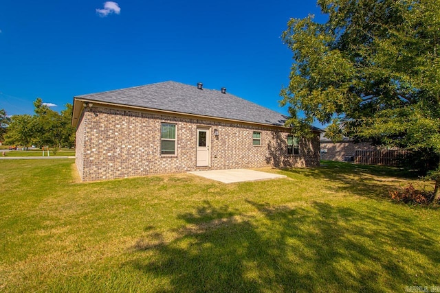 back of house with a patio area and a lawn