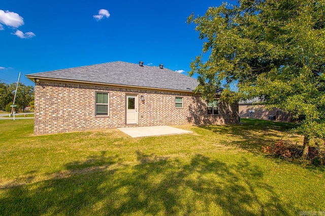 back of house featuring a lawn and a patio area