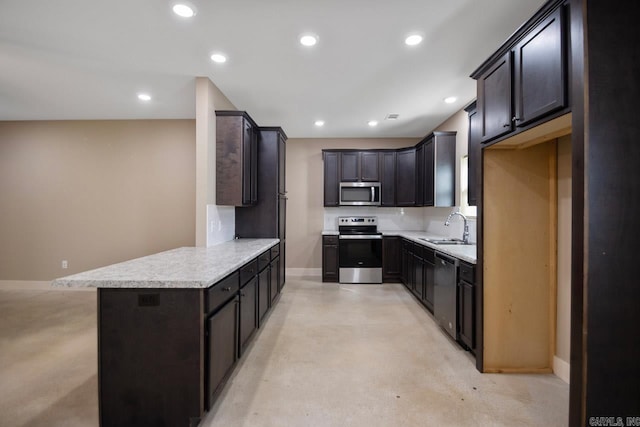 kitchen with dark brown cabinetry, sink, kitchen peninsula, backsplash, and appliances with stainless steel finishes