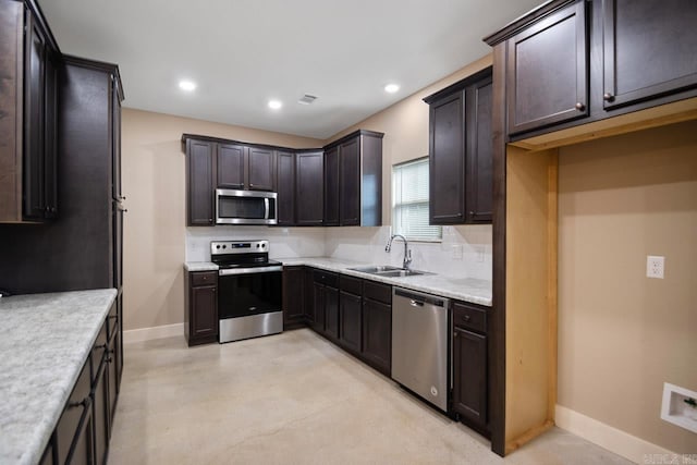 kitchen featuring light stone counters, dark brown cabinetry, sink, and stainless steel appliances