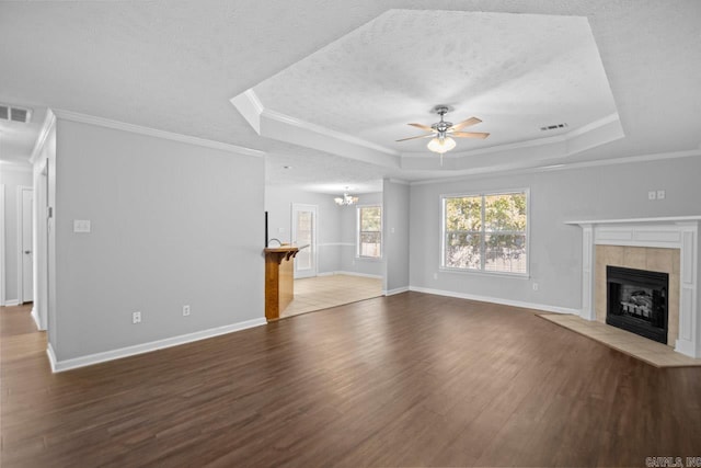 unfurnished living room with a raised ceiling, wood-type flooring, ceiling fan with notable chandelier, and ornamental molding