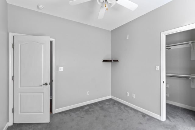 unfurnished bedroom featuring a closet, dark colored carpet, and ceiling fan