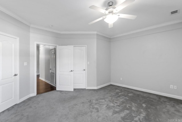 unfurnished bedroom with crown molding, dark carpet, and ceiling fan