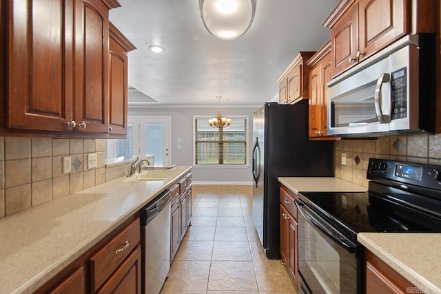 kitchen with an inviting chandelier, decorative light fixtures, sink, stainless steel appliances, and backsplash