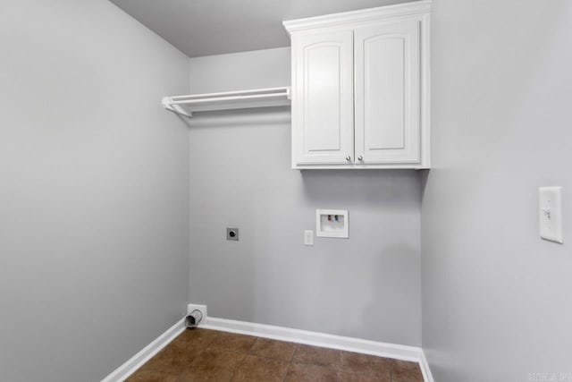 washroom featuring dark tile patterned floors, hookup for a washing machine, hookup for an electric dryer, and cabinets