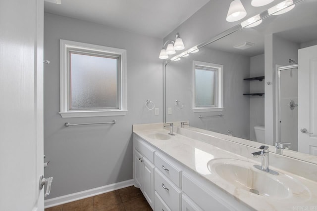 bathroom with plenty of natural light, vanity, toilet, and a shower with shower door