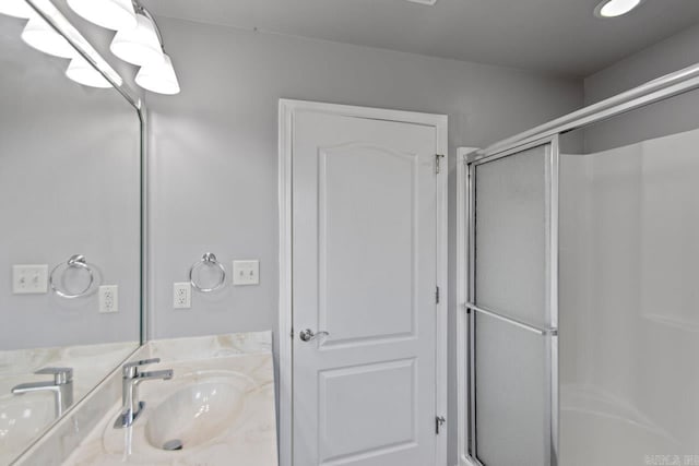 bathroom with walk in shower and vanity