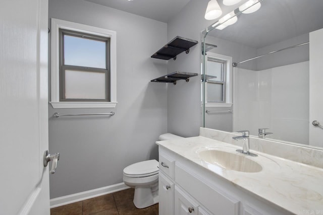 bathroom featuring tile patterned floors, vanity, toilet, and a wealth of natural light