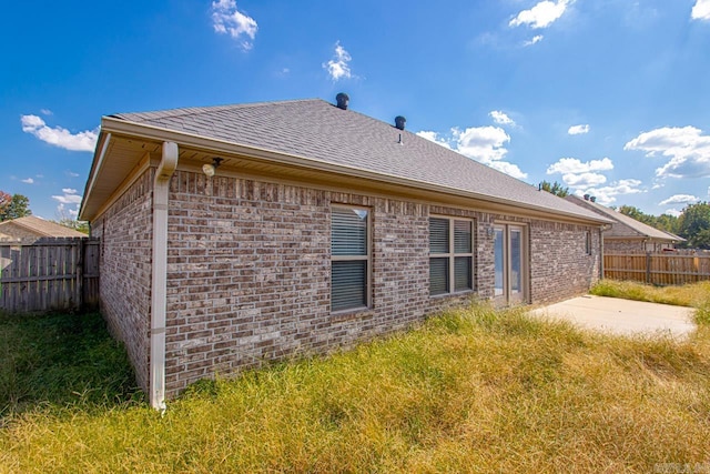 view of side of property featuring a yard and a patio area