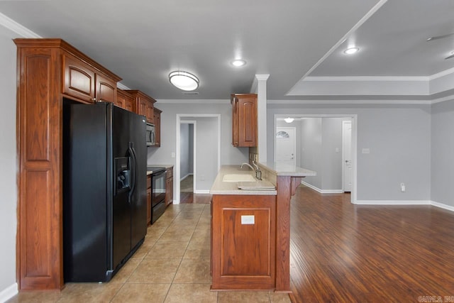 kitchen featuring light hardwood / wood-style floors, black appliances, sink, and ornamental molding